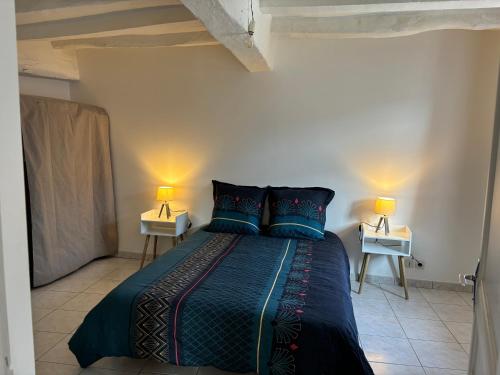 une chambre avec un lit avec deux lampes sur deux tables dans l'établissement Apparemment brissac, à Brissac-Quincé