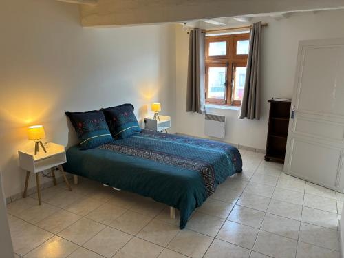 une chambre avec un lit avec des draps bleus et une fenêtre dans l'établissement Apparemment brissac, à Brissac-Quincé