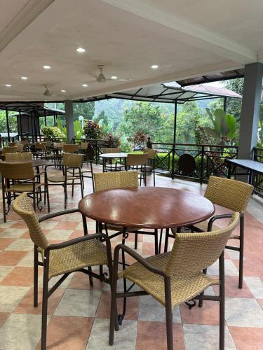 LiLLA Hilltop Retreats Janda Baik formerly known as Serene Resort في بينتونغ: فناء فيه طاولات وكراسي في مطعم