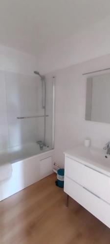 ein weißes Badezimmer mit einem Waschbecken und einem Spiegel in der Unterkunft Paris / Disney 6 Personnes in Noisy-le-Grand