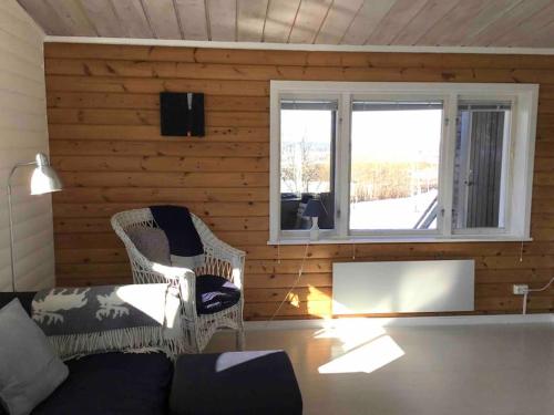 a living room with a couch and two windows at Loberget Oviken in Oviken