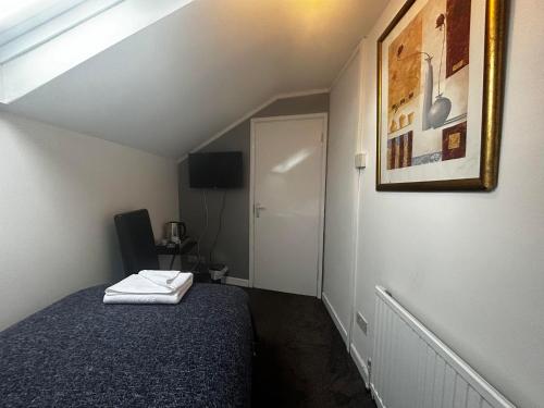 チェルトナムにあるThe London Innのベッドと椅子付きの小さな部屋です。