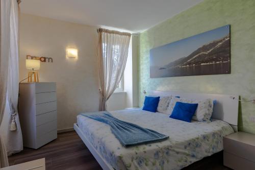 a bedroom with a bed with blue pillows at Villa Vitali - Bellagio in Bellagio