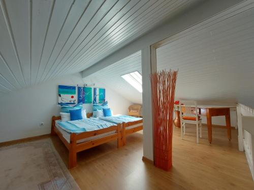 Zimmer im Dachgeschoss mit einem Bett und einem Tisch in der Unterkunft Ferienhaus-Zandt in Zandt
