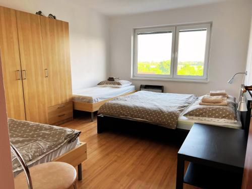 Un dormitorio con dos camas y una ventana. en Dovolenkový byt Pomaranč Teplý Vrch, en Teplý Vrch