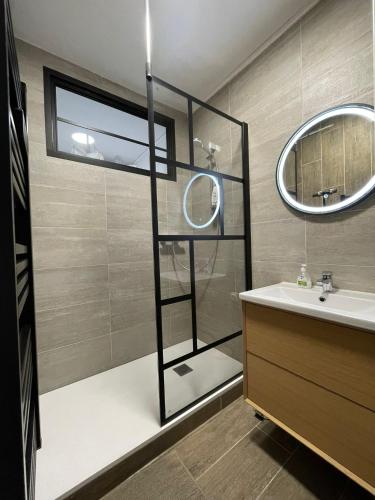une salle de bain avec une douche, un lavabo et un miroir dans l'établissement T3 en duplex hyper centre de Bourg en Bresse, à Bourg-en-Bresse