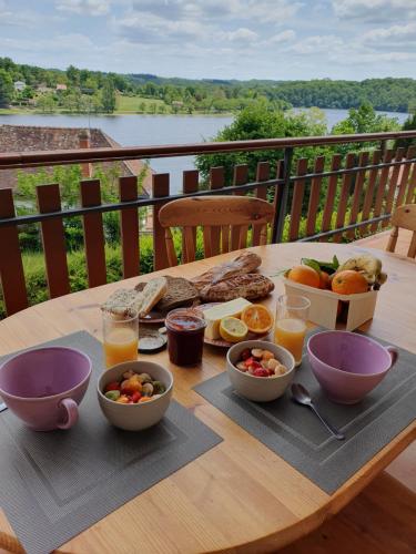 - une table avec de la nourriture et des boissons sur le balcon dans l'établissement Les mimosas du Lac Vue panoramique sur le lac, à Éguzon-Chantôme