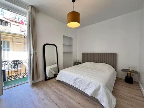 une chambre avec un lit et une grande fenêtre dans l'établissement Centre Ville, près de Casino et gare de Monaco, à Beausoleil