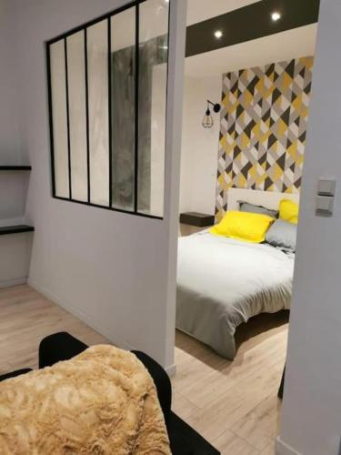 une chambre avec un lit avec des oreillers jaunes dans l'établissement Joliette European Hospital Appartment, à Marseille