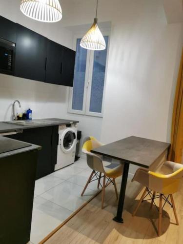 une cuisine avec une table et des chaises ainsi qu'un lave-linge dans l'établissement Joliette European Hospital Appartment, à Marseille