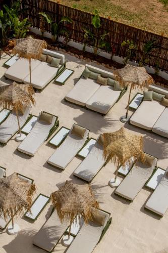 a group of lounge chairs and umbrellas on a patio at Hotel Galfi - Boutique & Adults Only in San Antonio
