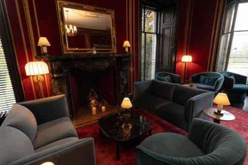 a living room with blue chairs and a fireplace at The Scott in Edinburgh