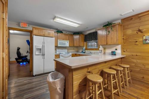 a kitchen with a white refrigerator and wooden cabinets at Poplar Point Condo Unit 12A by Eden Crest in Pigeon Forge