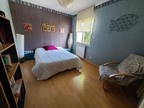 une chambre avec un lit et une chaise dedans dans l'établissement Belle maison, à Bruguières