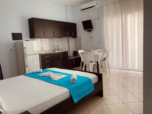 a bedroom with a bed and a kitchen with a table at Vila Brisild in Ksamil