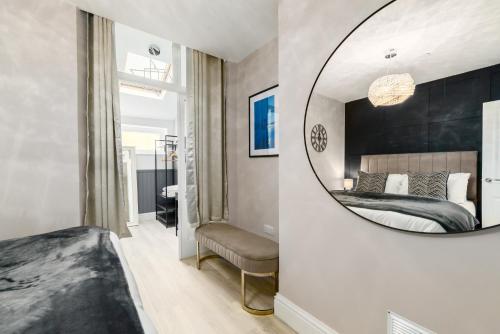 a bedroom with a large mirror and a bed at Ty Ayla Premier Apartments - Roath Park in Cardiff