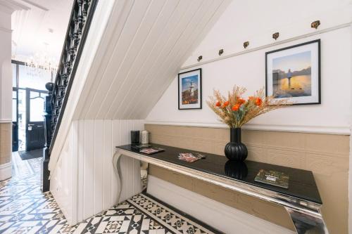 a hallway with a table and flowers on a wall at Ty Ayla Premier Apartments - Roath Park in Cardiff
