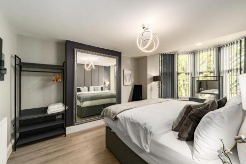 a bedroom with a large bed and a large mirror at Ty Ayla Premier Apartments - Roath Park in Cardiff