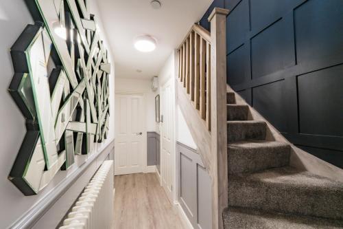 a hallway with a staircase with black and white art on the wall at Ty Ayla Premier Apartments - Roath Park in Cardiff