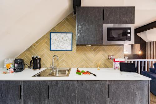 a kitchen with a sink and a counter top at Ty Ayla Premier Apartments - Roath Park in Cardiff