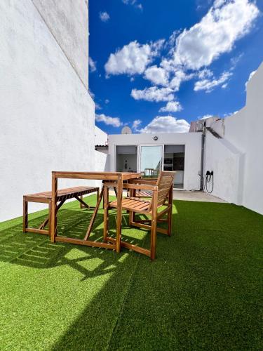 a wooden table and bench on a green lawn at Casa Dos Borrachos in Aldeia do Mato