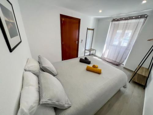 a bedroom with a white bed with a yellow box on it at Casa Dos Borrachos in Aldeia do Mato