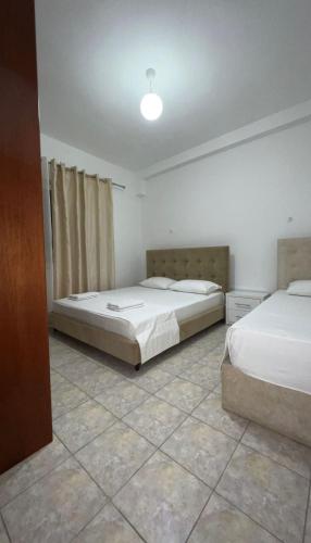 a bedroom with two beds and a light on the ceiling at Villa Mirjan in Sarandë