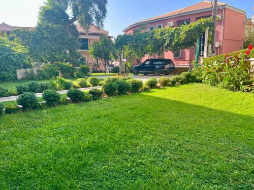 a yard with a car parked in front of a house at Valentinos House in Parga