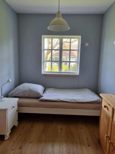 a bedroom with a bed and a window at Ferienhaus Norderpiep 54 in Friedrichskoog