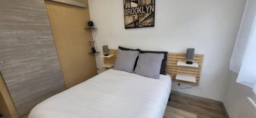 a small bedroom with a white bed with two pillows at L'Aloe Vera in Plan-de-la-Tour