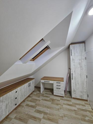 an attic room with a vaulted ceiling and a desk at Apartman Sky in Sremska Mitrovica