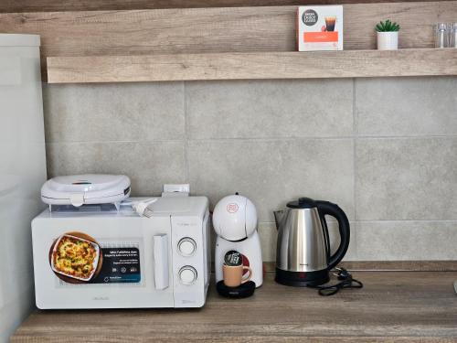 a kitchen counter with a microwave with a plate of food at Apartman Sky in Sremska Mitrovica
