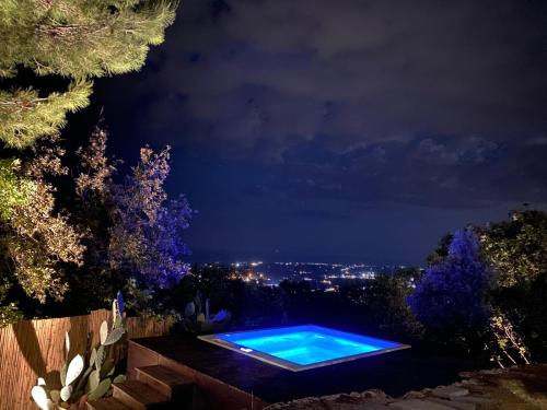 a swimming pool is lit up at night at Trulli della Chiesetta in Selva di Fasano