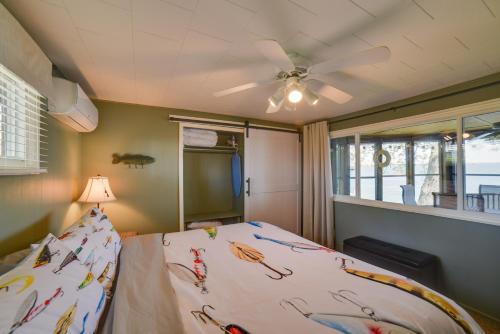 a bedroom with a bed with a ceiling fan at Dreamy Lake Poinsett Cabin with Deck, Dock and Views! in Arlington