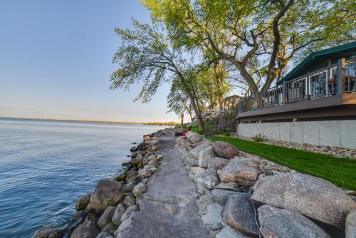 a rock retaining wall next to a house and the water at Dreamy Lake Poinsett Cabin with Deck, Dock and Views! in Arlington