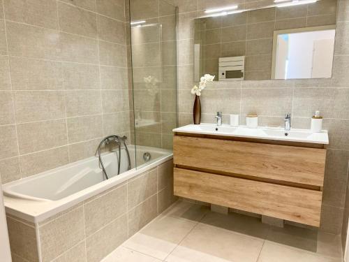 a bathroom with a sink and a tub and a mirror at Panoramic Sea View Appartment Blue Pearl in Nice