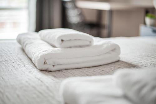 three towels stacked on top of a bed at The Lambeth Apartment in London