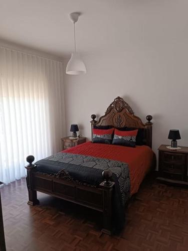 a bedroom with a bed with a red comforter at Casa da Mimosa, a 100 metros da praia de Vila Chã in Vila Chã