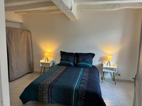 une chambre avec un lit avec deux lampes sur deux tables dans l'établissement Appartement Situé au cœur de Brissac-Quincé, à Brissac-Quincé