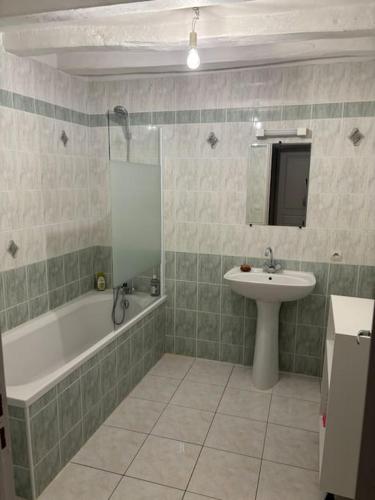 une salle de bain avec un lavabo et une baignoire et un lavabo dans l'établissement Appartement Situé au cœur de Brissac-Quincé, à Brissac-Quincé