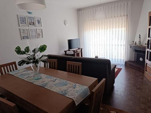 a living room with a table and a couch at Casa da Mimosa, a 100 metros da praia de Vila Chã in Vila Chã