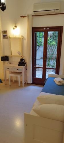 a bedroom with a bed and a desk and a window at Hotel Sofia in Matala