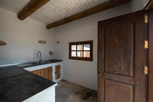 a kitchen with a sink and a wooden door at Finca Luz in Puerto del Rosario
