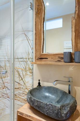 a bathroom with a stone sink and a mirror at Hyggelig in Westerland