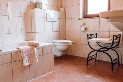 uma casa de banho com uma banheira, um WC e um lavatório. em Schmidtburger Hof em Weiler
