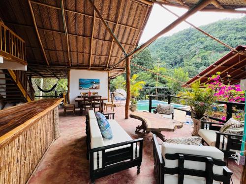 an outdoor patio with chairs and tables and a view of a mountain at Minca cabaña la roca in Santa Marta