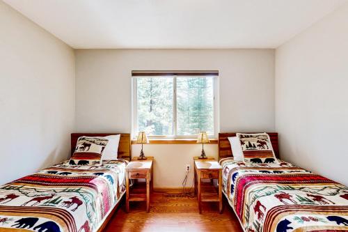サウス・レイクタホにあるSunlit Forest Havenのデスク、窓が備わるドミトリールームのベッド2台分です。