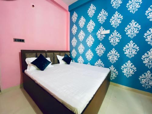 a bedroom with a bed with pink and blue walls at The Narayan Bhawan , ramanuj ashram ,haridas nagar ,ramkot ayodhya ji in Ayodhya