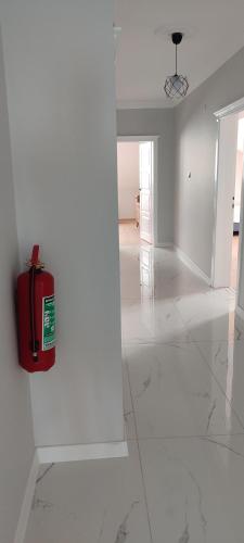 a white room with a red fire extinguisher on the wall at Zumra's White Houses in Trabzon
