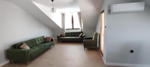 a living room with a green couch and two chairs at Zumra's White Houses in Trabzon